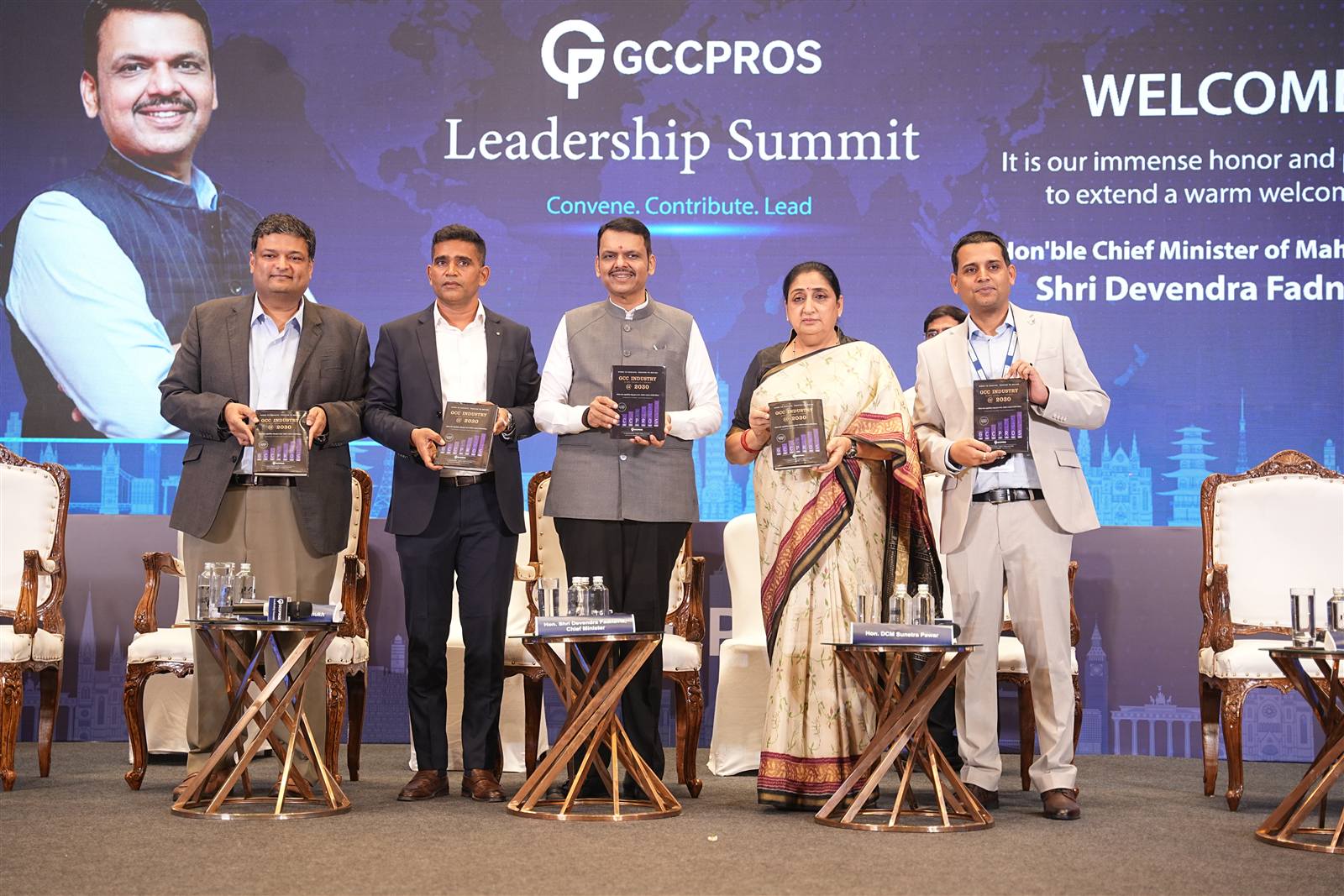 Chief Minister Devendra Fadnavis, Deputy Chief Minister Sunetra Pawar and Shammi Prabhakar holding copies of GCC Industry @ 2030 on stage